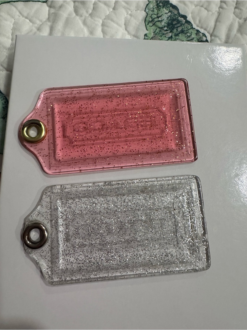Two Coach glitter tags